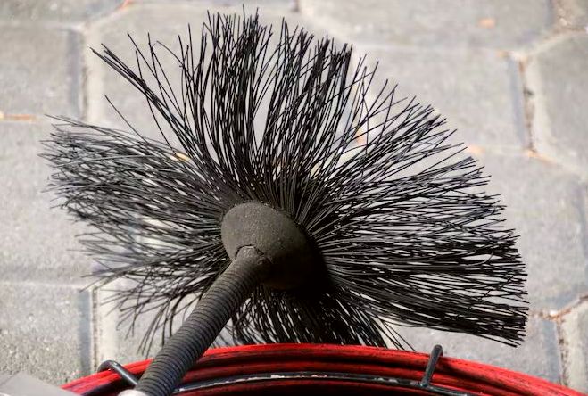 Poly flue brush head resting on a coiled line