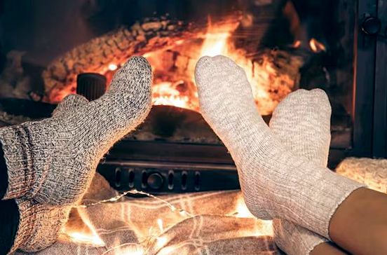 Wool socks warming before a bright fireplace